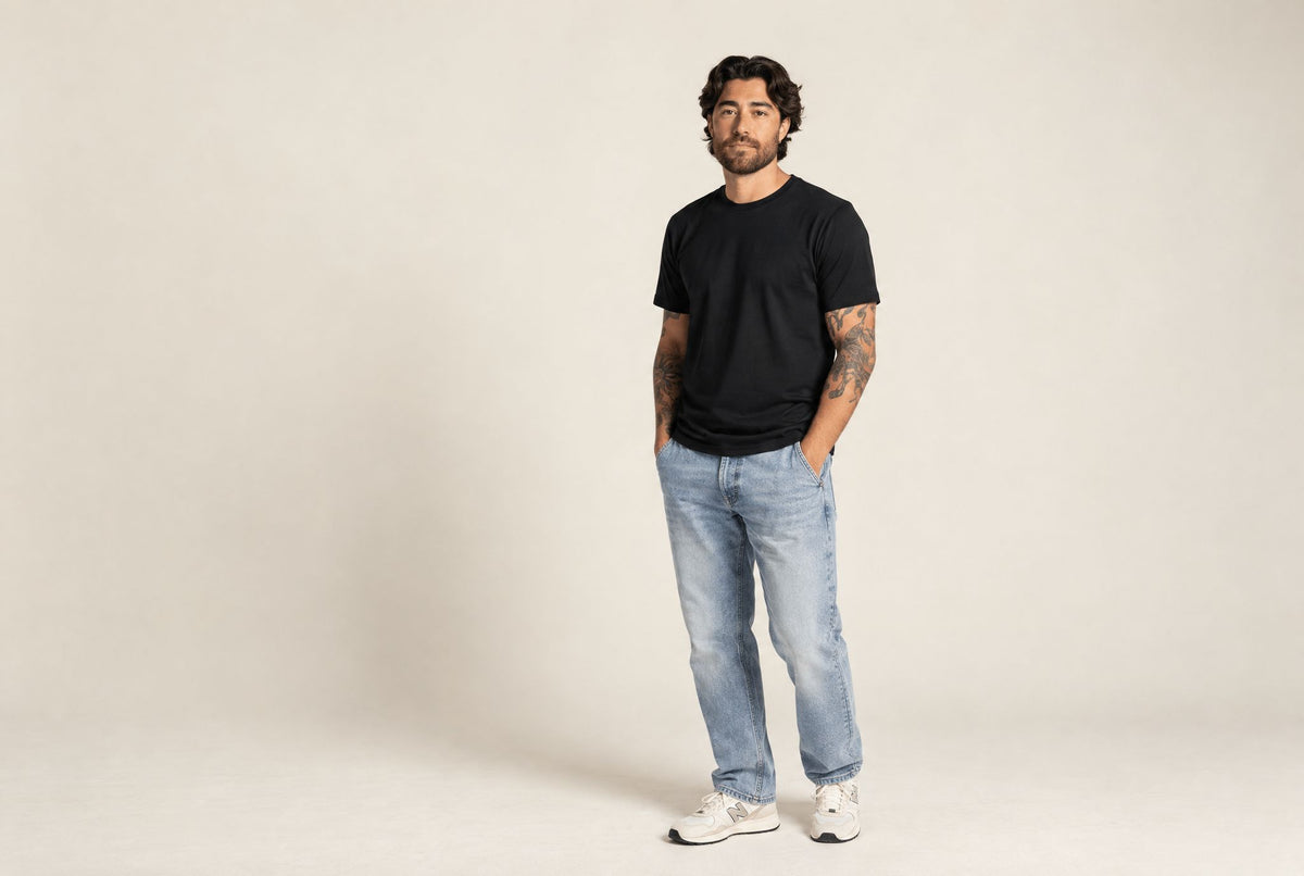 Man in a black LEBASQ crew neck T-shirt and light jeans